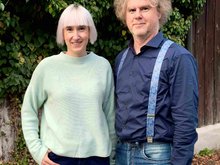 Stefanie Auer und Markus Scheuermann stehen vor einer begrünten Holzwand