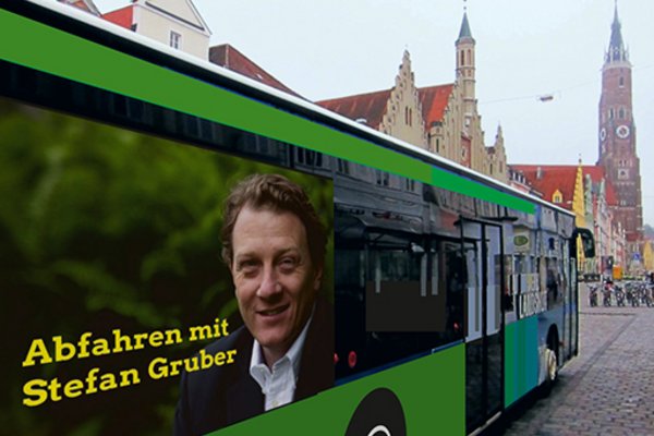 Stadtbus vor Stadtkulisse mit Aufdruck "Abfahren mit Stefan Gruber"