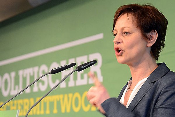 Sigi Hagl spricht energisch mit erhobenen linkem Zeigefinger im Bernlochner-Saal in zwei Mikrophone. Im Hintergrund ein grünes Transparent mit der Aufschrift "Politischer Aschermittwoch"