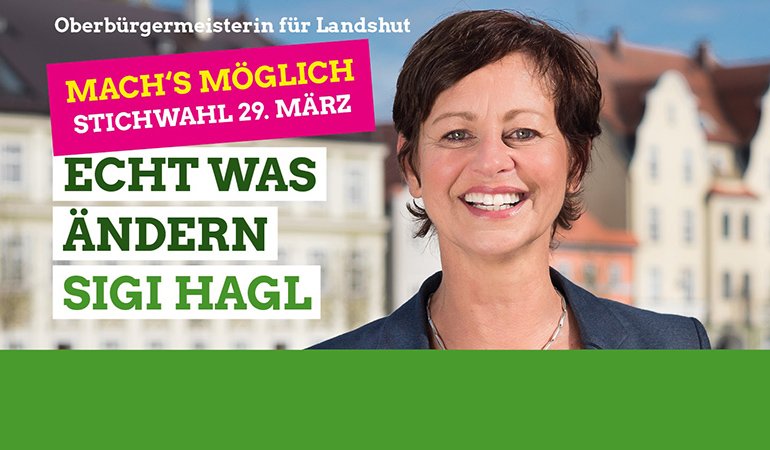 Sigi Hagl vor Landshuter Häusern am Isargestade und daneben die Schrift "Mach's möglich. Stichwahl 29. März - Echt was ändern - Sigi Hagl"