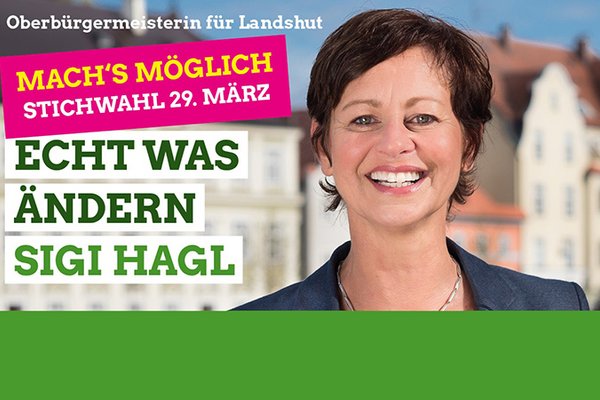 Sigi Hagl vor Landshuter Häusern am Isargestade und daneben die Schrift "Mach's möglich. Stichwahl 29. März - Echt was ändern - Sigi Hagl"