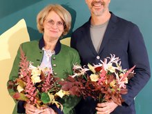Spitzenduo Iris Haas und Christoph Rabl mit bunten Blumensträußen vor einem Grünen-Rollup