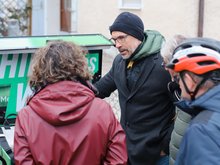 Christoph Rabl spricht neben grünem Lastenrad mit Interessierten