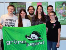 Johannes Schlieter, Jasmin Beinlich, Pascal Pohl, Jasmin Faulstich, Cameron Simoleit und Sarah Schöps (v.l.n.r.) hinter einer Grünen Jugend-Fahne und vor Grünen Plakaten