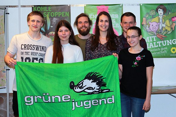 Johannes Schlieter, Jasmin Beinlich, Pascal Pohl, Jasmin Faulstich, Cameron Simoleit und Sarah Schöps (v.l.n.r.) hinter einer Grünen Jugend-Fahne und vor Grünen Plakaten