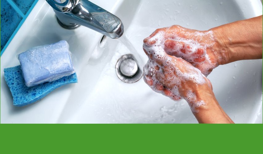 unter einem laufenden Wasserhahn waschen sich zwei eingeschäumte Hände, ein Stück Seife liegt am Waschbeckenrand