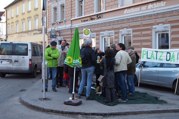 mehrere Personen mit Tisch auf einem grünen Teppich vor der Pizzeria am Bismarckplatz