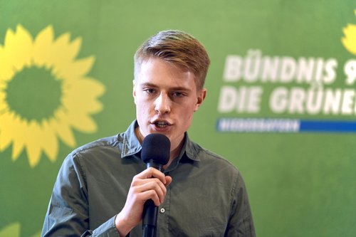 Johannes Hunger spricht vor grünem Hintergrund in Mikrofon, Listenplatz 4 Landtag