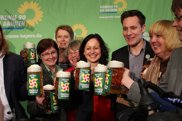 Dr. Anton Hofreiter, Rosi Steinberger, Hedwig Borgmann, Gisela Floegl, Sigi Hagl, Ludwig Hartmann, Claudia Roth, Sascha Müller stoßen mit Maßkrügen an, auf denen steht: "Rettet die Energiewende" mit einem Bild eines Windrades