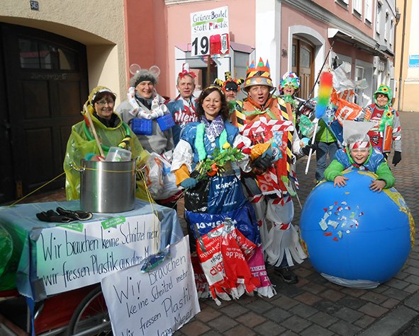 In Plastik gekleidetes Prinzenpaar samt Gefolge mit dem Slogan "Wir brauchen keine Schnitzel mehr - wir fressen Plastik aus dem Meer." und einer Weltkugel