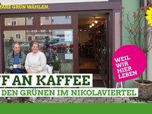zwei Menschen sitzen gemütlich vor dem Café "Maison de Nicola" und warten