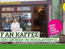 zwei Menschen sitzen gemütlich vor dem Café "Maison de Nicola" und warten