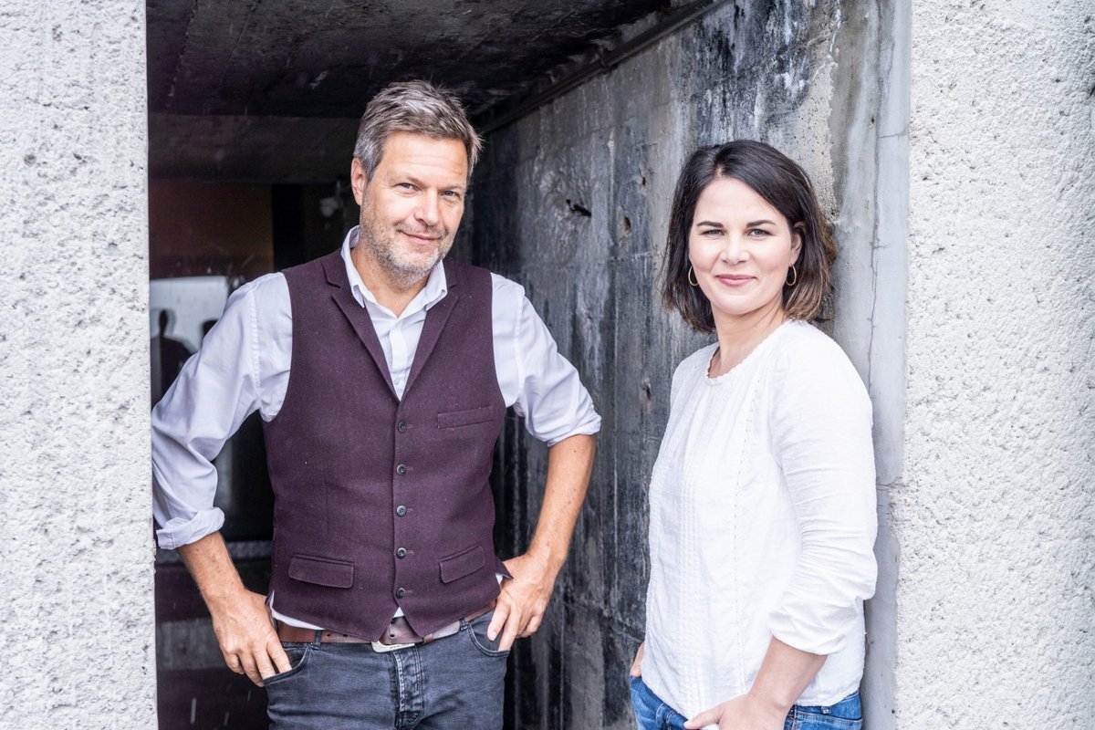 Robert Habeck und Annalena Baerbock stehen nebeneinander in einem Durchgang aus rohem Beton und sehen uns freundlich, aber etwas frech an (Foto: Dominik Butzmann)